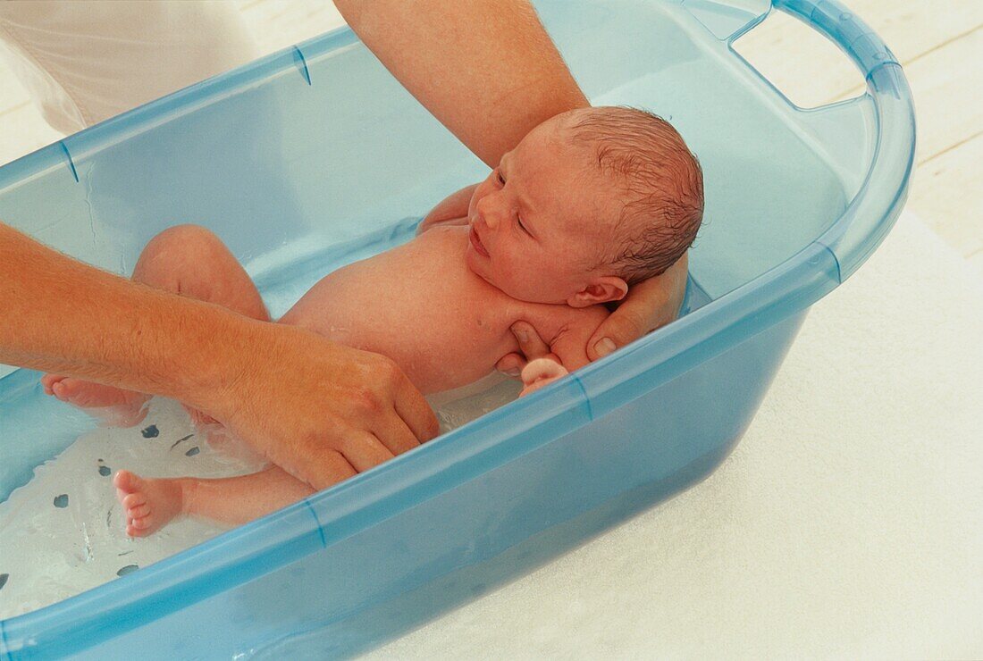 Man bathing baby boy