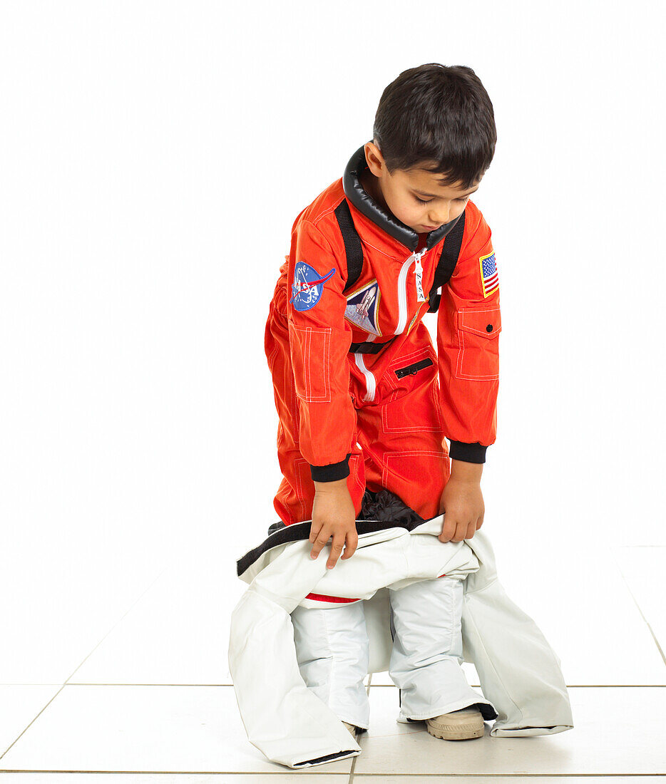Boy pulling space suit on