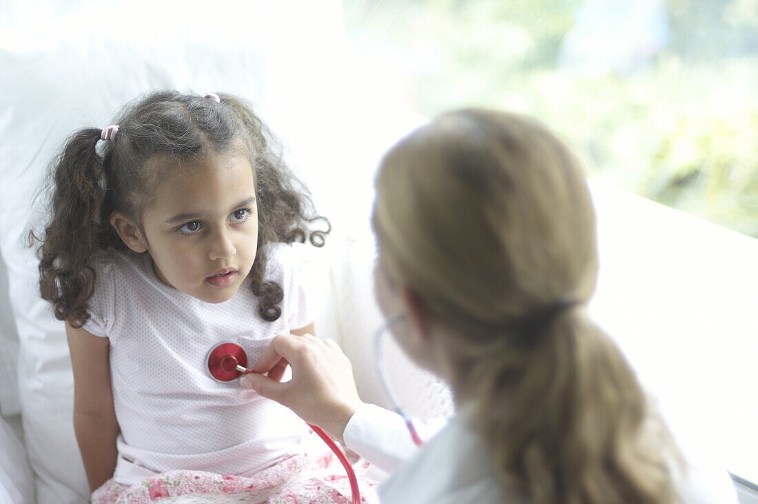 Doctor holding a stethoscope on the chest of a girl