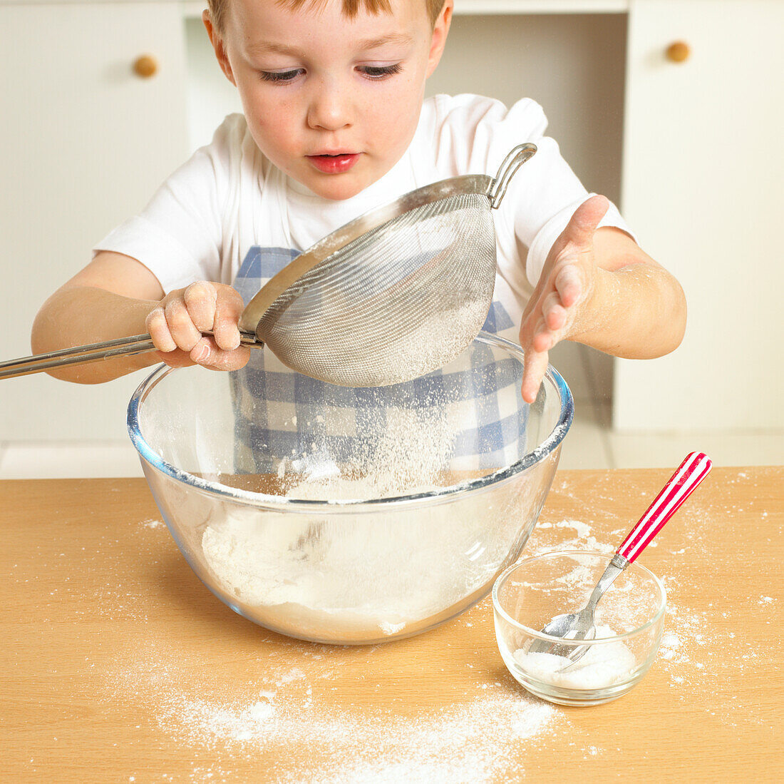 Boy holding sieve with flour