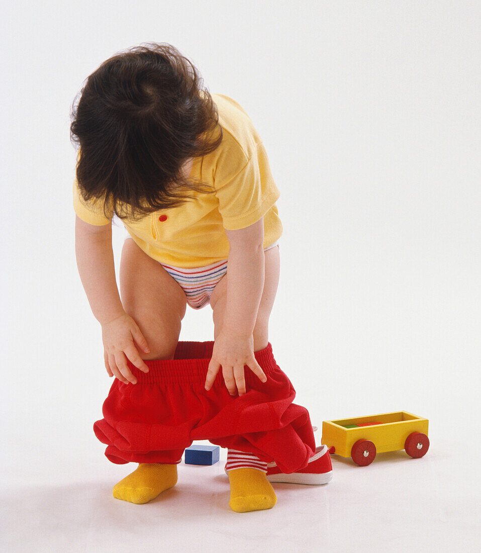 Toddler pulling trousers up