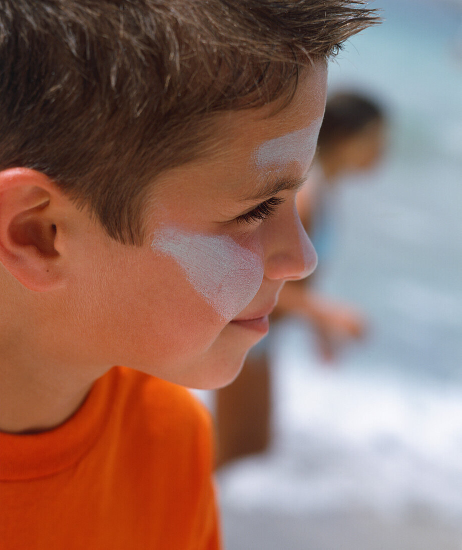Boy with sun lotion smeared on his face