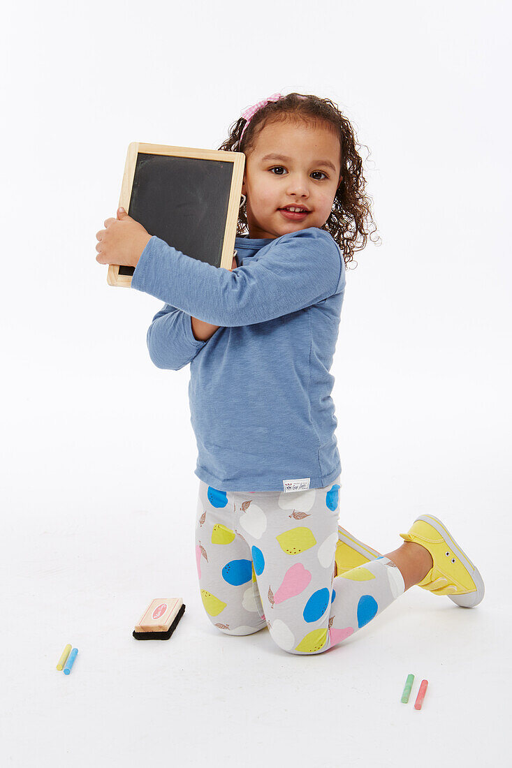 Little girl playing with chalk board