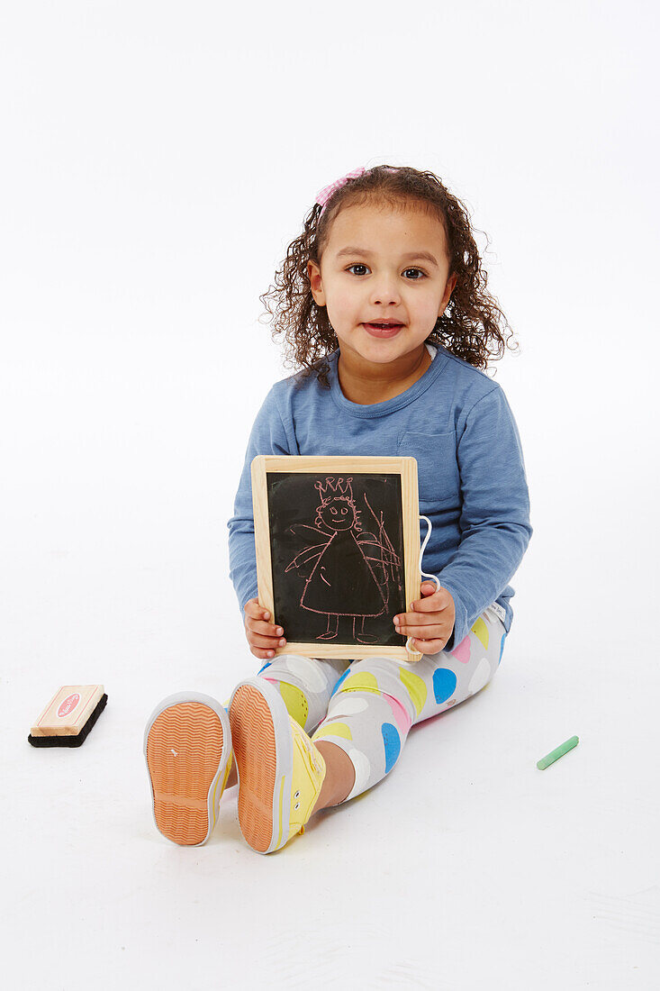Little girl playing with chalk board