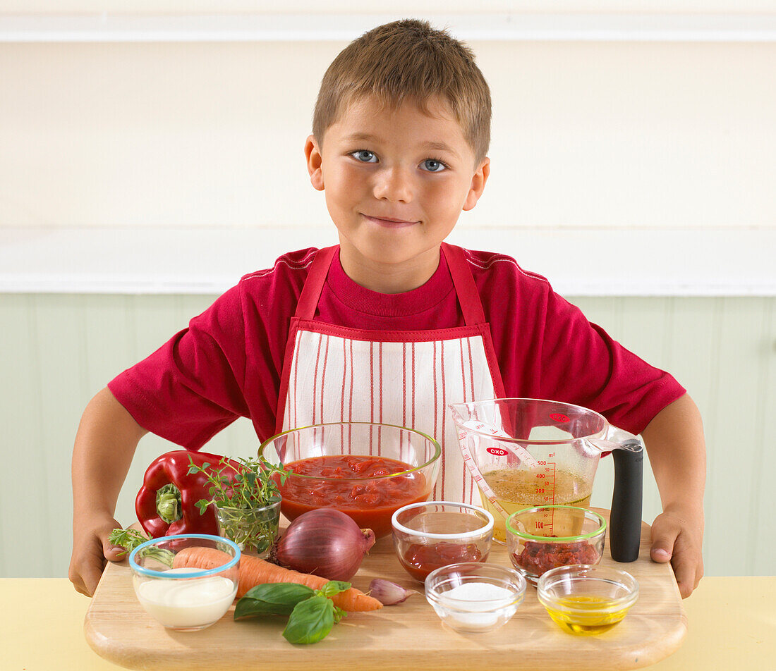Boy holding the ingredients for tomato soup