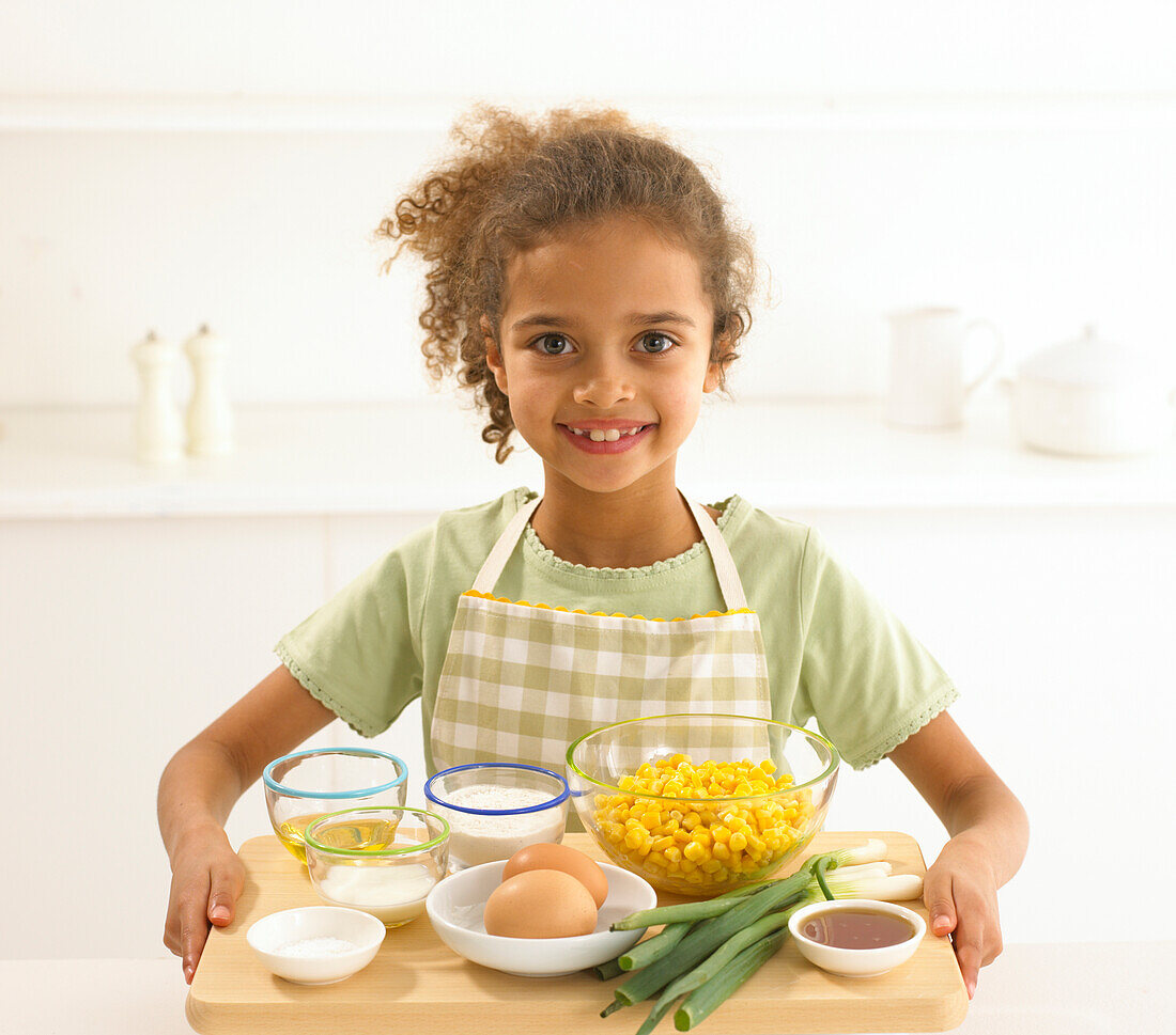 Girl holding the ingredients for sweetcorn fritters