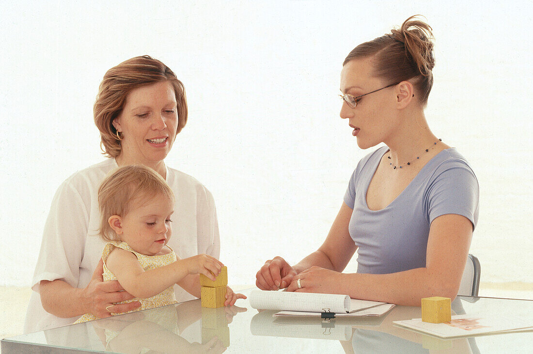 Two adults and a child sitting at a table
