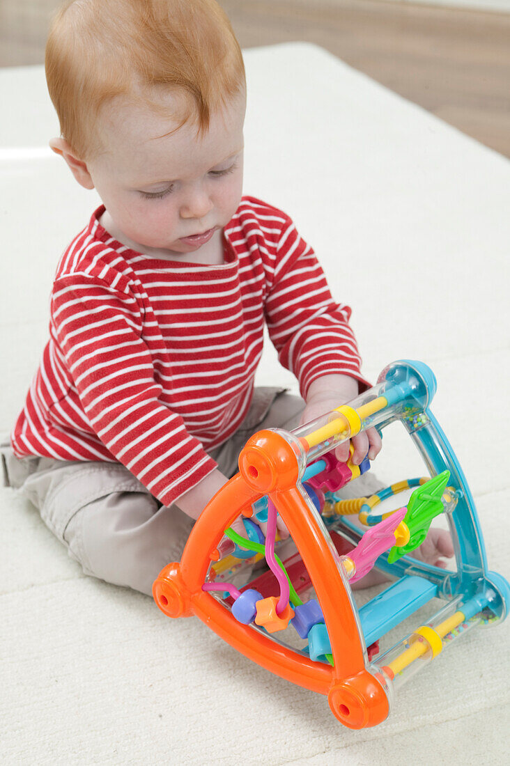 Baby boy playing with abacus style plastic toy