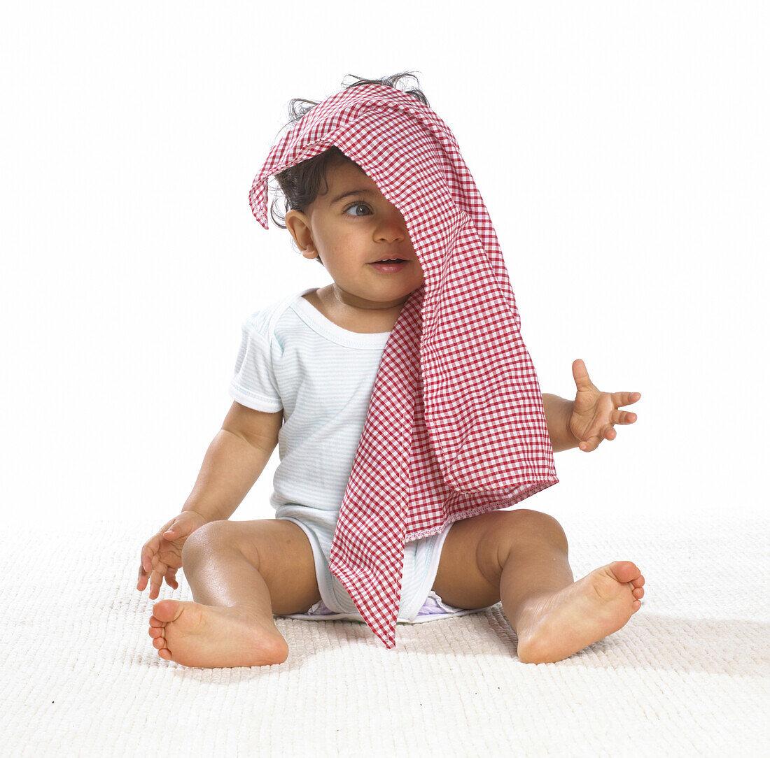Baby boy with tea towel on head
