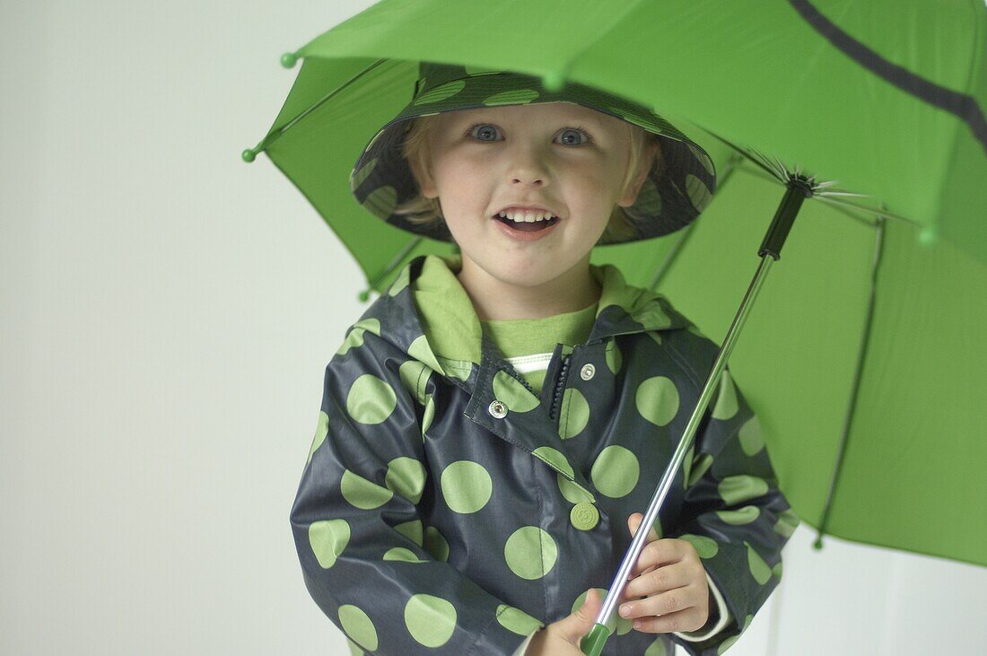 Boy holding green umbrella