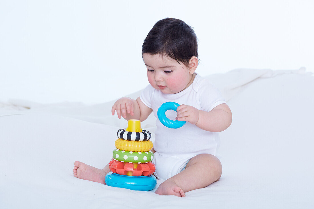 Baby girl playing with plastic ring toy