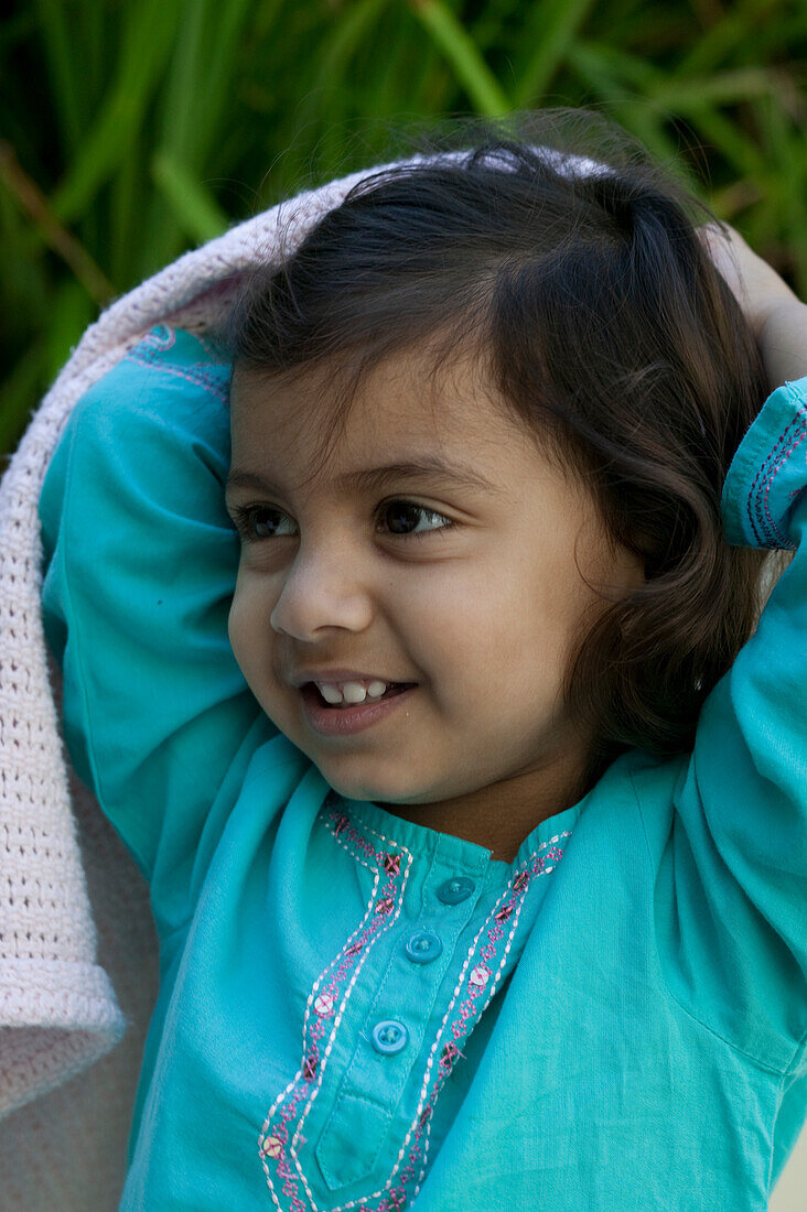 Girl lifting white blanket over her head