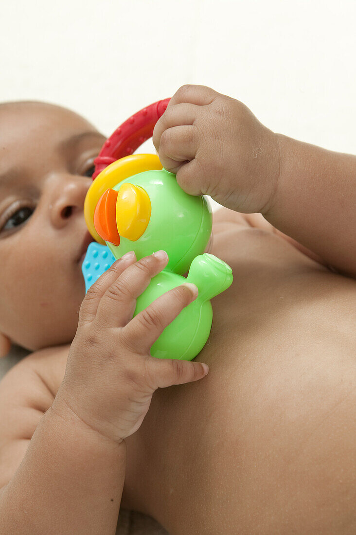 Baby boy playing with plastic toy