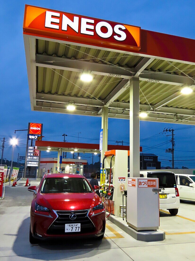 Woman using petrol pump, Japan