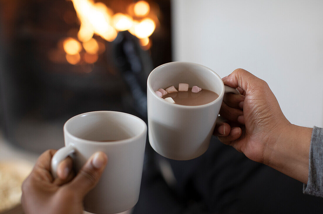 Women drinking hot cocoa at cosy fireside