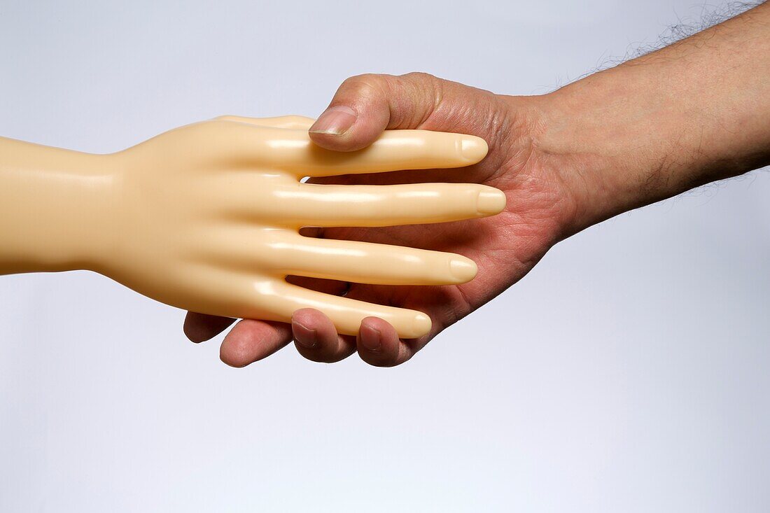 Human hand shaking artificial hand