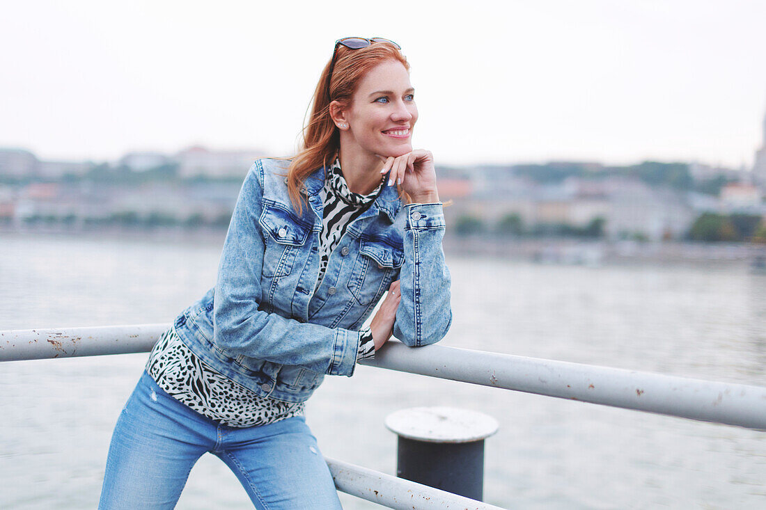 Smiling woman looking away at riverbank