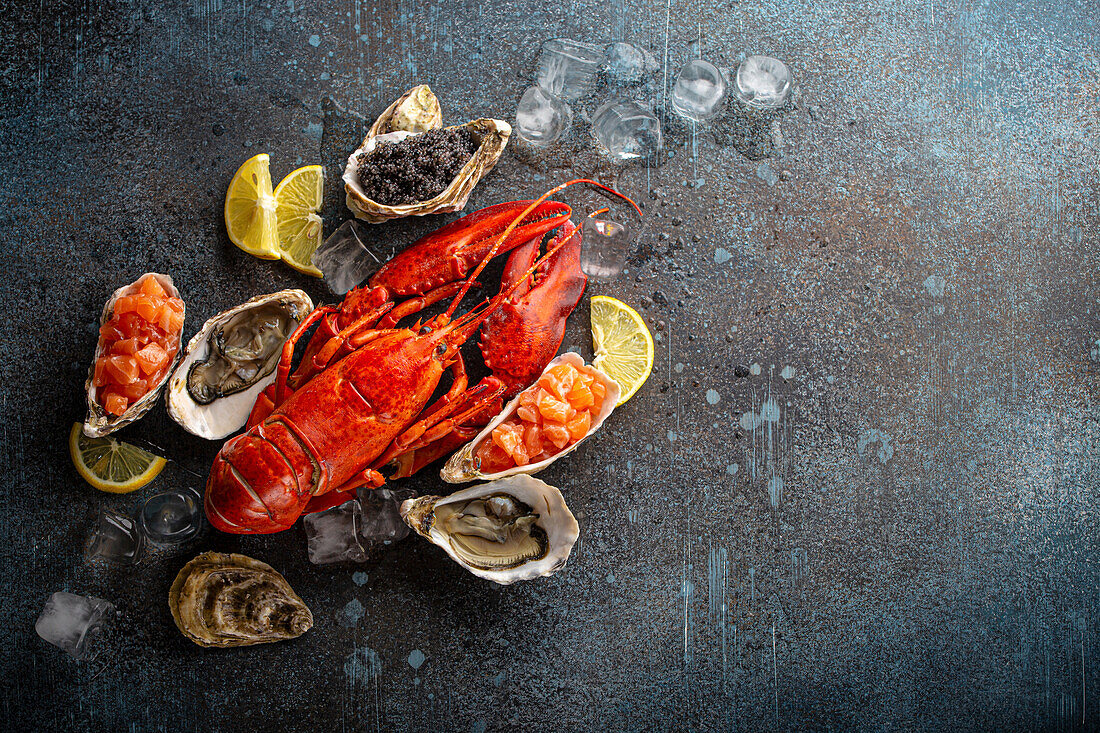 Seafood plate with cooked red whole lobster, fresh open oysters, black caviar and salmon tartare