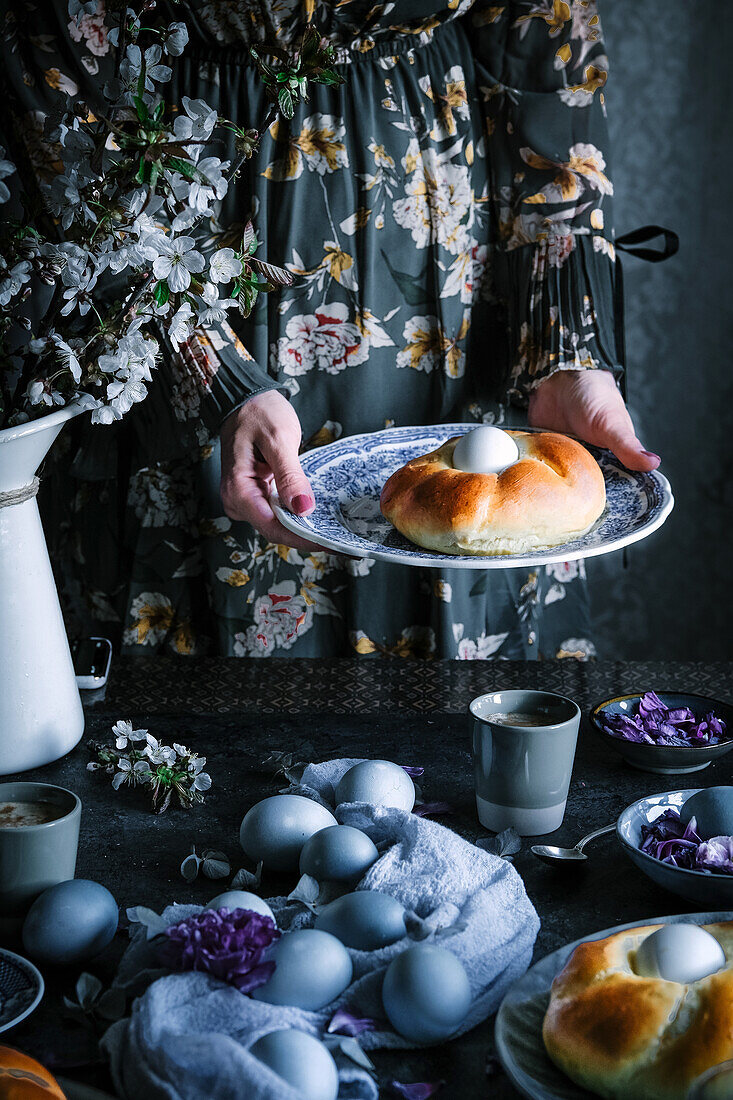 Easter table with coloured eggs and yeast wreath