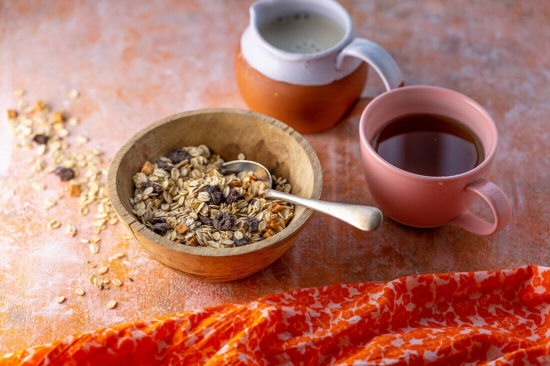 Muesli in a wooden bowl with milk and coffee