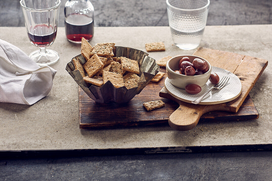 Rosemary crackers with sea salt served with olives and red wine