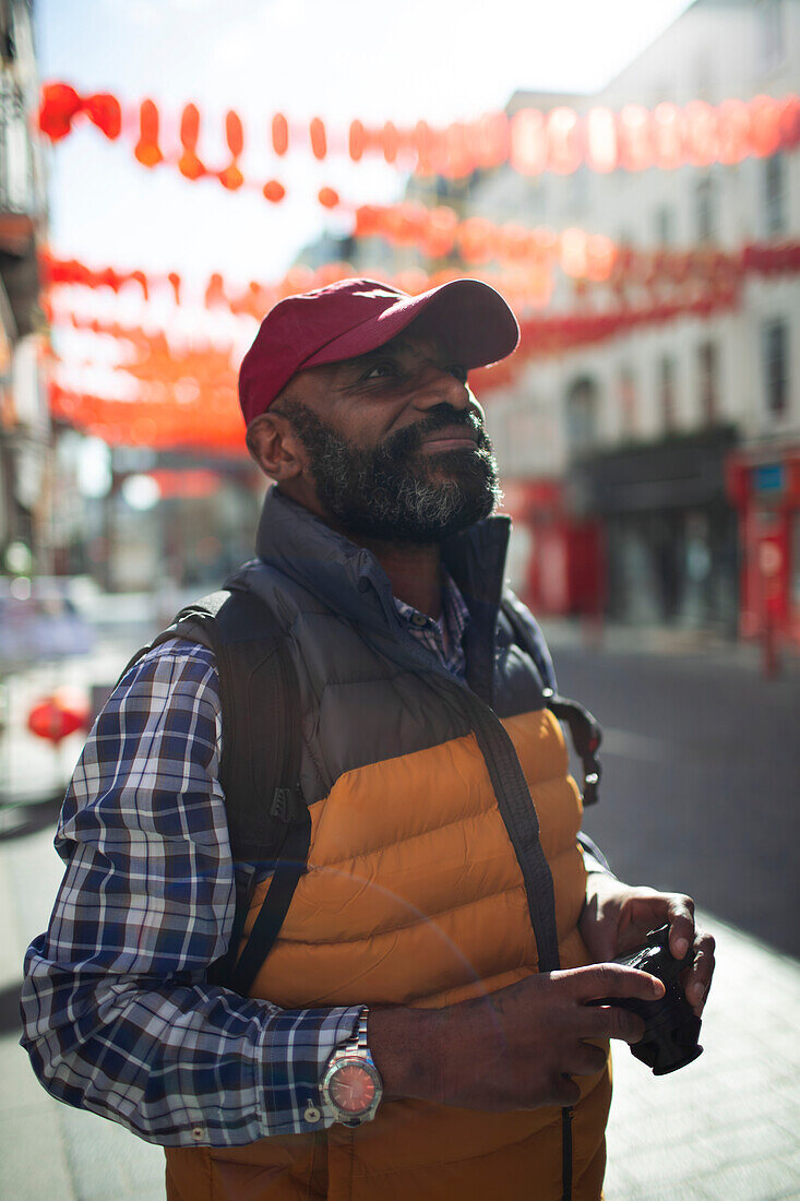 Mature male tourist on sunny city street