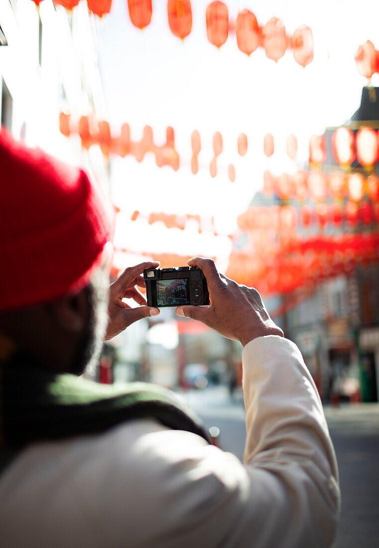Male tourist with digital camera on city street