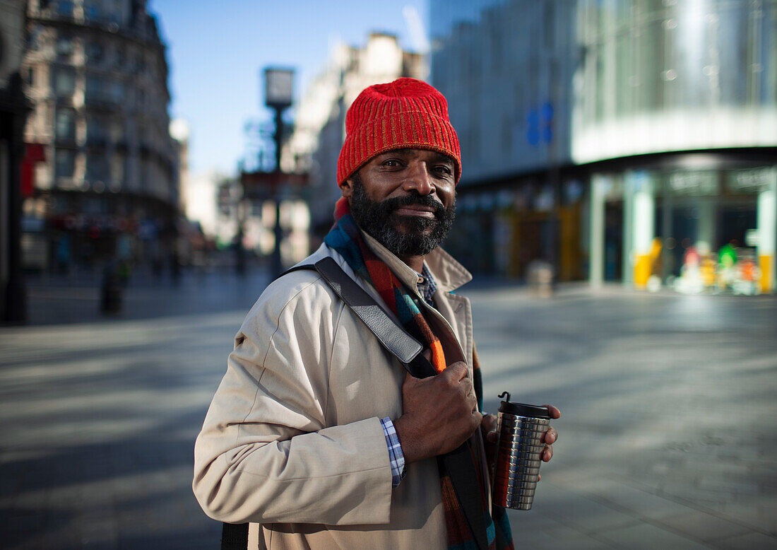 Confident businessman in stocking cap on city street