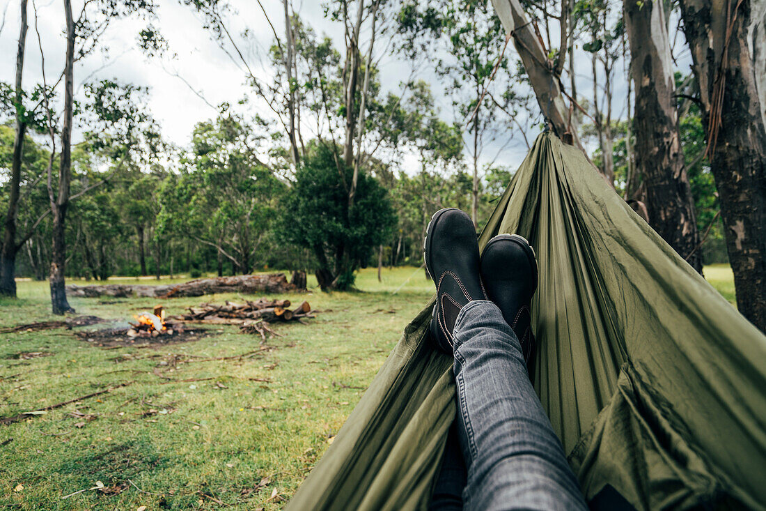 Man relaxing with feet up at campsite, Australia