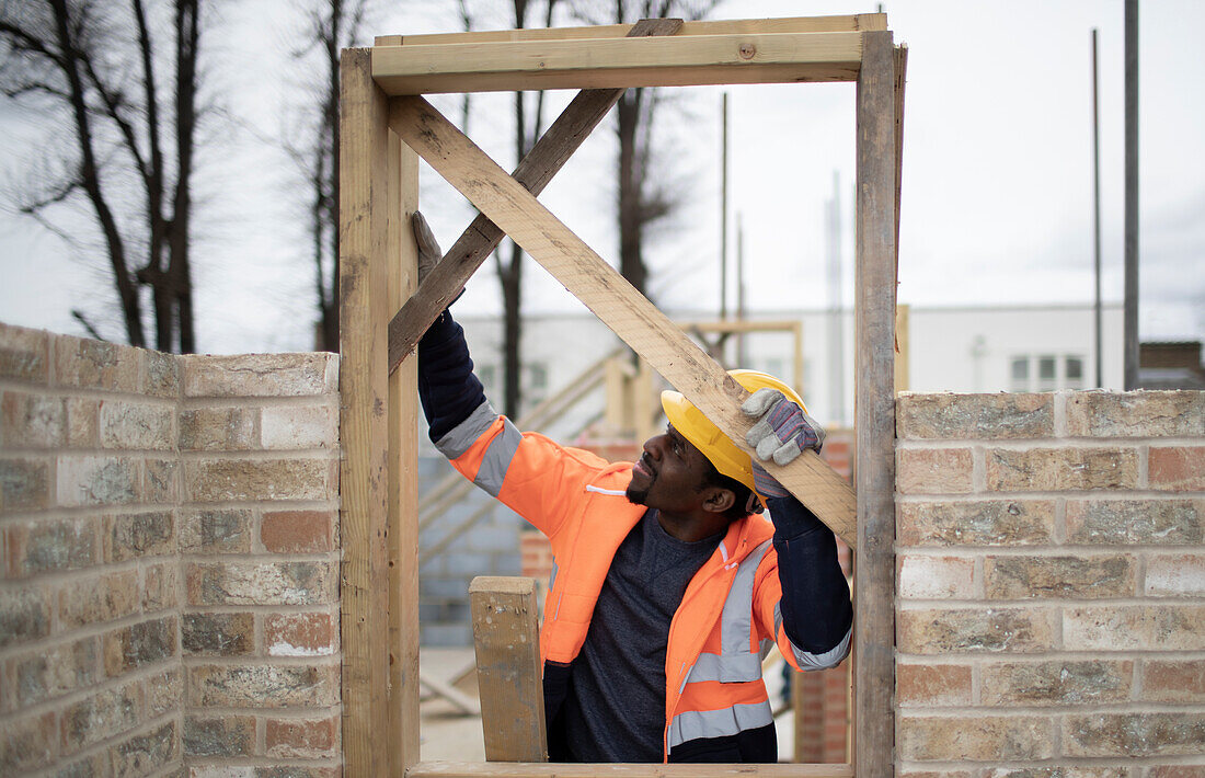 Construction worker installing door frame