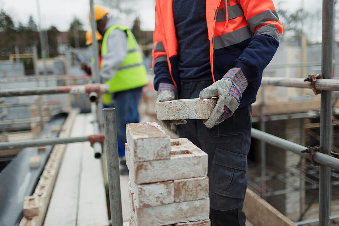 Construction worker laying bricks at construction site