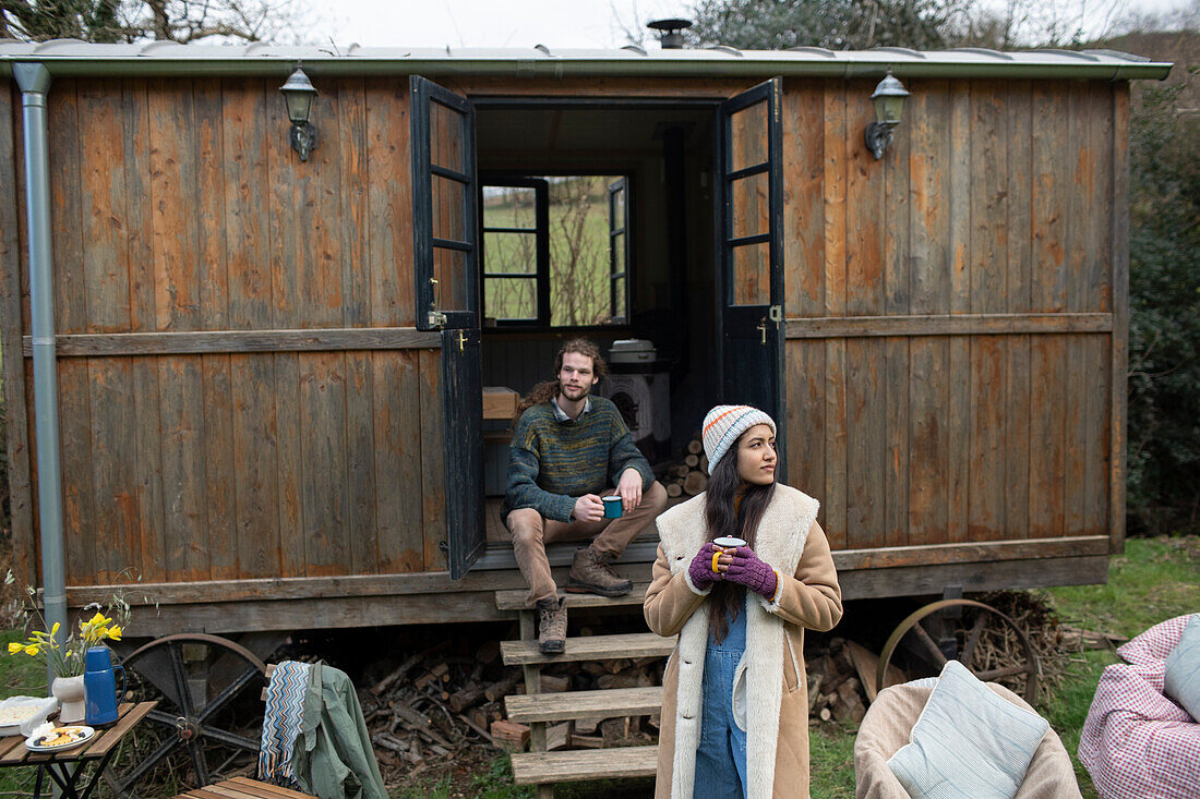 Couple enjoying coffee outside tiny cabin rental