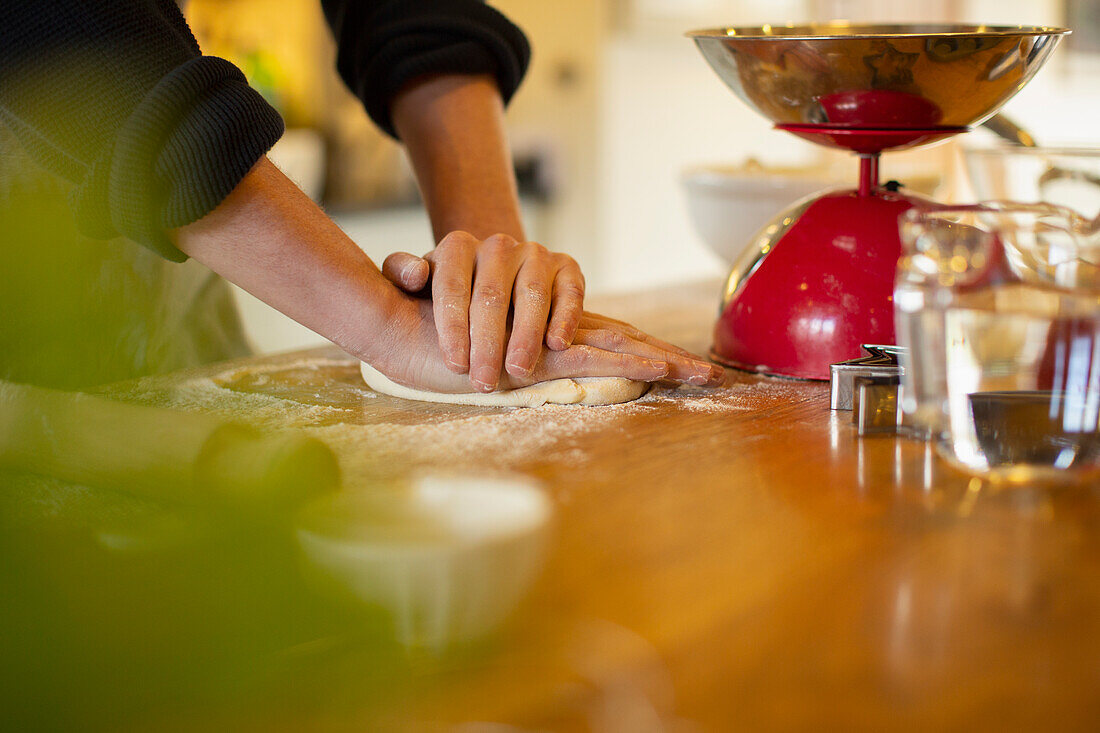 Man rolling out homemade dough on kitchen counter