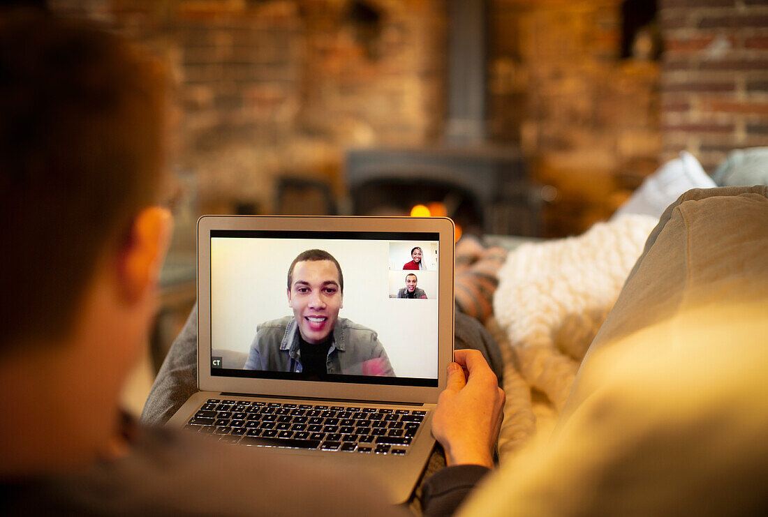 Man video conferencing with colleagues on laptop screen