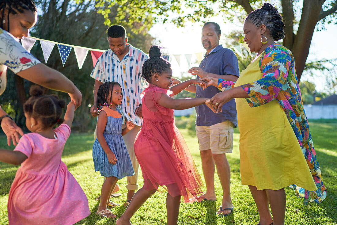 Carefree multigenerational family dancing in backyard