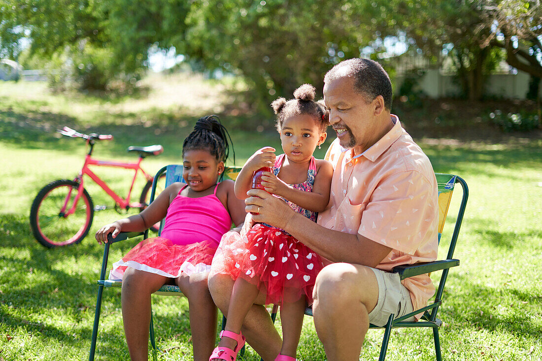 Grandfather and granddaughters in park