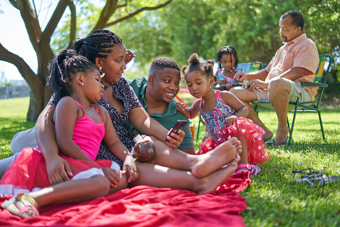 Family relaxing on blanket in park