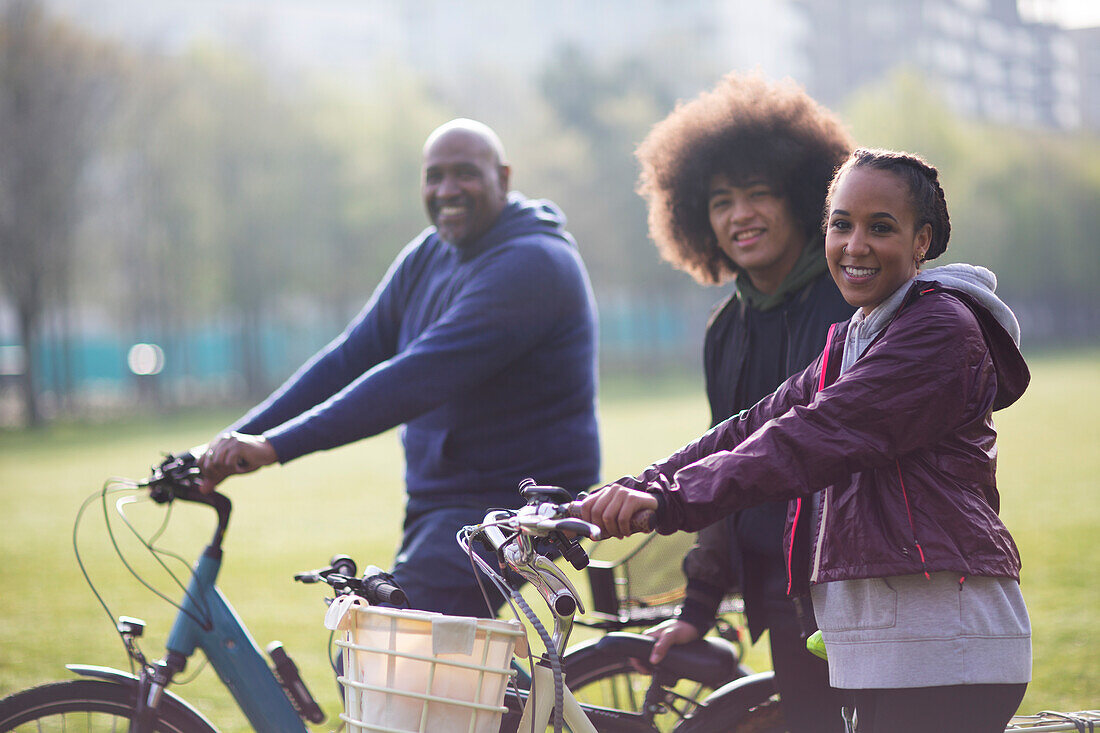 Happy father and teen kids with bicycles in park