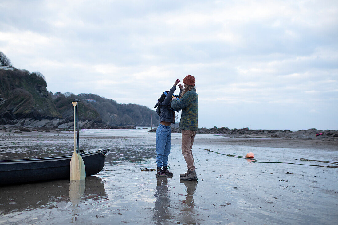 Couple preparing for canoeing on beach