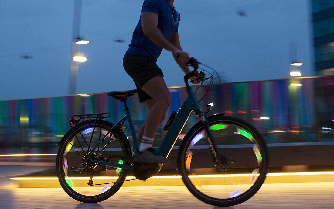 Man riding illuminated bike at night