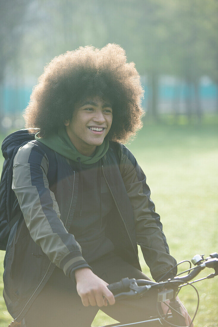 Happy young man on bicycle in park