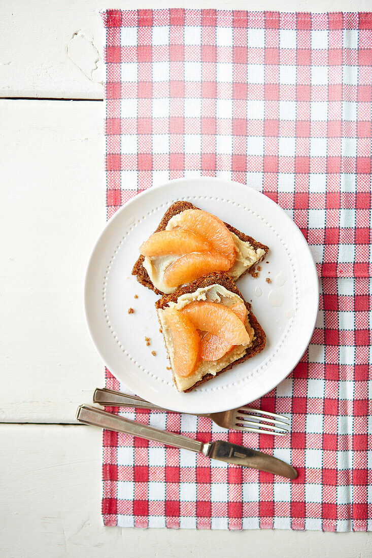 Rye bread with almond butter and pink grapefruit segments