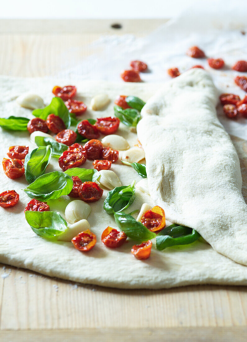 Making pizza pockets with oven-dried cherry tomatoes, garlic, and basil