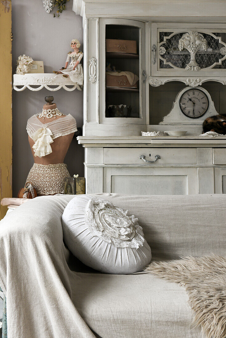 View over sofa on dressmaker's mannequin and on old sideboard with clock