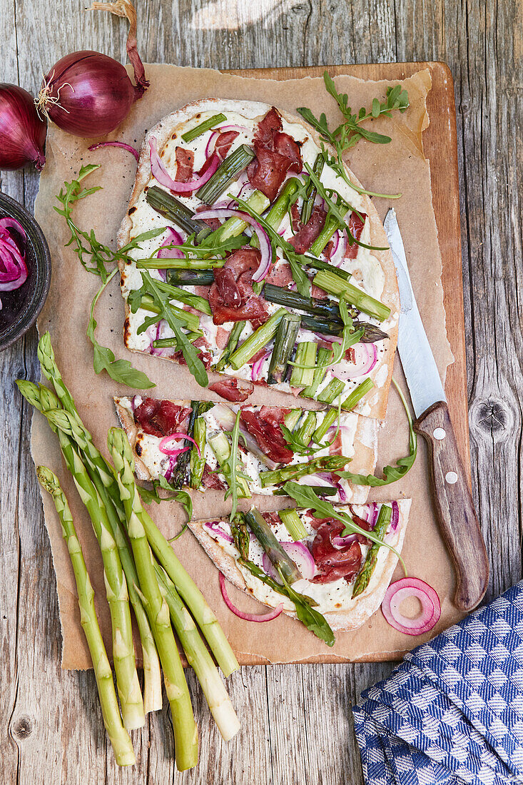 Tarte flambée with green asparagus, red onions and bresaola