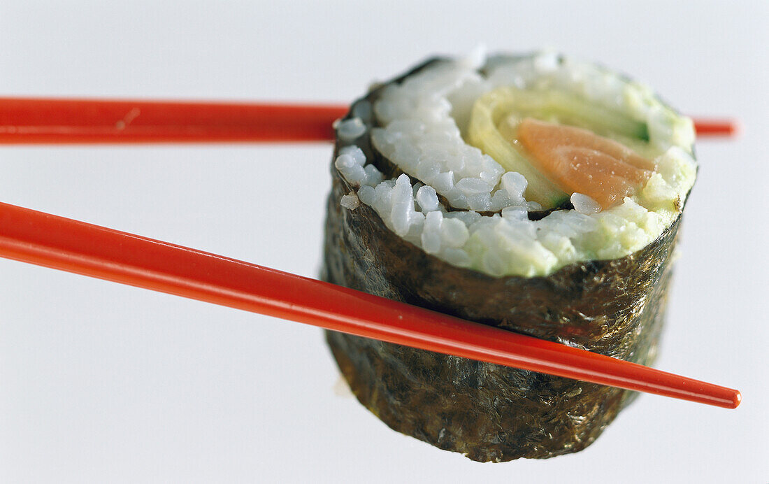 Maki-Sushi mit roten Essstäbchen