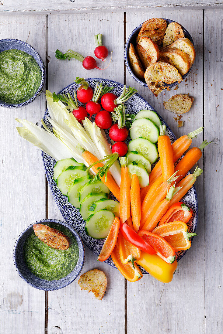 Raw vegetables served with bread chips and salsa verde