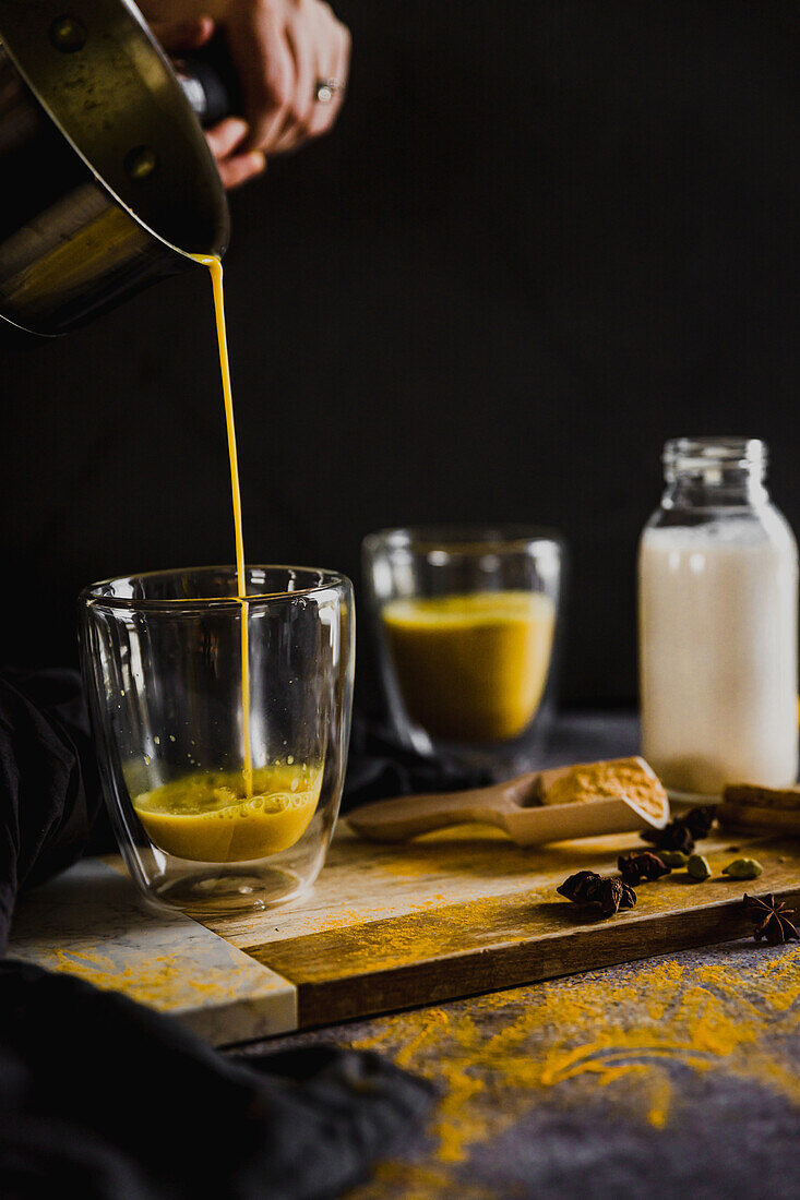 Pouring turmeric milk into a glass