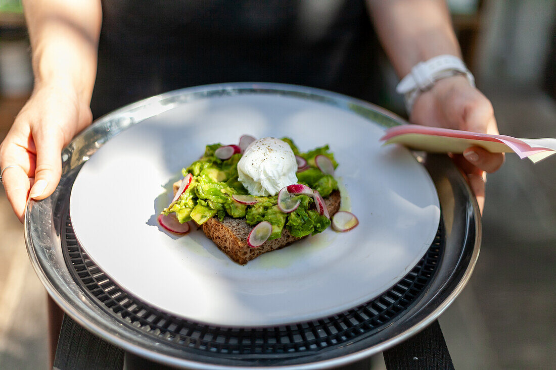 Toast mit Avocado, pochiertem Ei und Radieschen