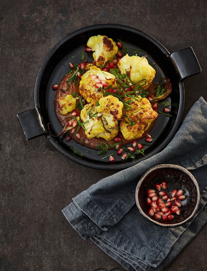 Vegan cauliflower with pomegranate seeds in walnut sauce